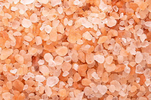 Himalayan salt, coarse crystals, macro photo. Rock salt, halite, with a pinkish tint, due to trace minerals, mined from the Punjab region, primarily used as a food additive, or to replace table salt.