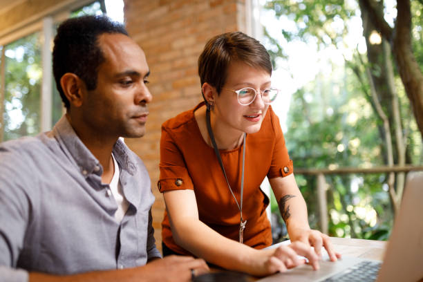 istock IT worker helping her coworker to solve problems on the laptop 1502507672