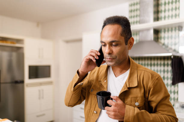 istock Mananswering a call in the office's kitchen 1502518121