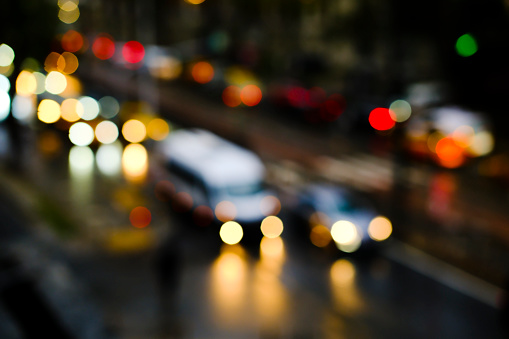 Blurry vehicles and bokeh lights on a road at night time in Istanbul. High-angle view of blurry traffic jam.