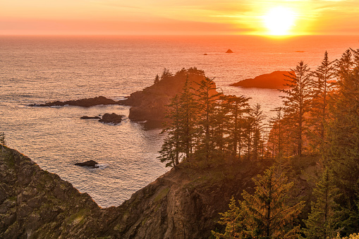 A colorful Sunset view of a rocky section of southern Oregon coast at Samuel H. Boardman State Scenic Corridor on a calm Spring evening. Oregon, USA.
