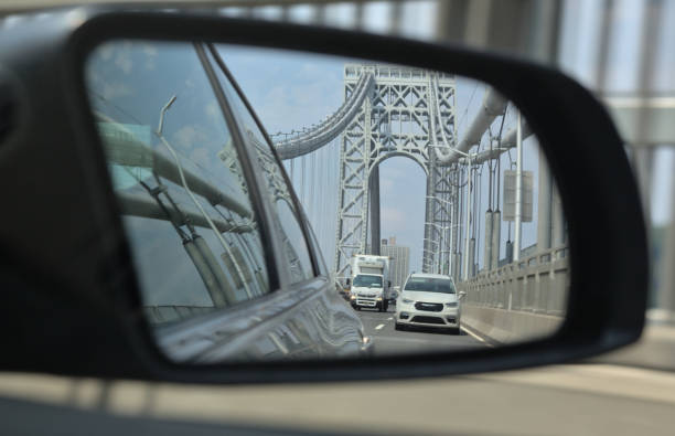 rear view mirror on george washington bridge (gwb, nyc) in new york with truck and car driving side view mirror view of road with george washington bridge (car, truck, road, traffic, highway) i95, gwb crossing new york to new jersey (washington heights, manhattan, nyc to fort lee) driving cars gwb stock pictures, royalty-free photos & images