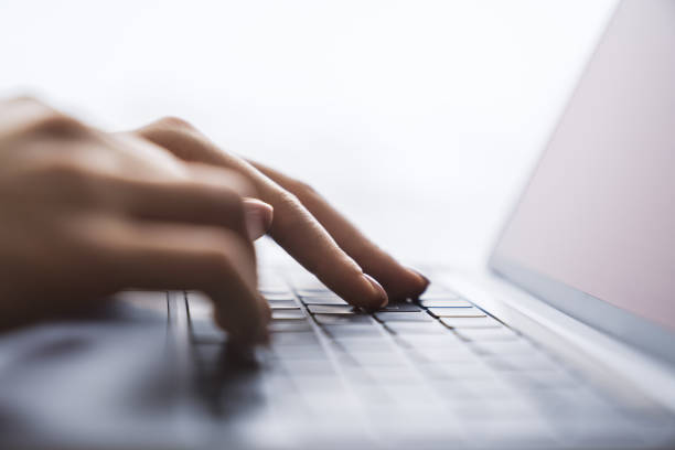 istock Set against a fuzzy office backdrop, the image presents a woman's hands typing on a modern laptop keyboard 1502537341