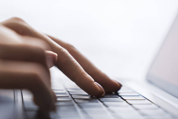 istock Set against a fuzzy office backdrop, the image presents a woman's hands typing on a modern laptop keyboard 1502537346