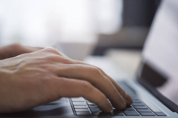 istock With the office setting blurred in the backdrop, the image shows a close-up of a man's hands typing on a contemporary laptop 1502537384