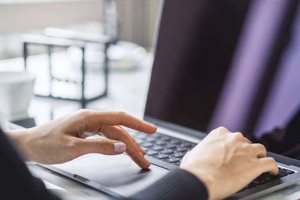 istock A woman's hands typing on a sleek laptop keyboard, with the office environment appearing hazy in the background 1502537409
