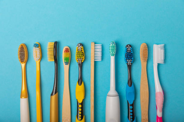 Electric and manual toothbrushes on a blue background. View from above. Oral hygiene. Ordinary toothbrush, eco and electric toothbrush. Oral hygiene. Oral Care Kit. Dentist concept. Dental care. cepillos de dientes eléctricos y manuales sobre fondo azul. vista desde arriba. higiene bucal. cepillo de dientes ordinario, cepillo de dientes ecológico y eléctrico. higiene bucal. kit de cuidado bucal. concepto de dentista. odontólogos.