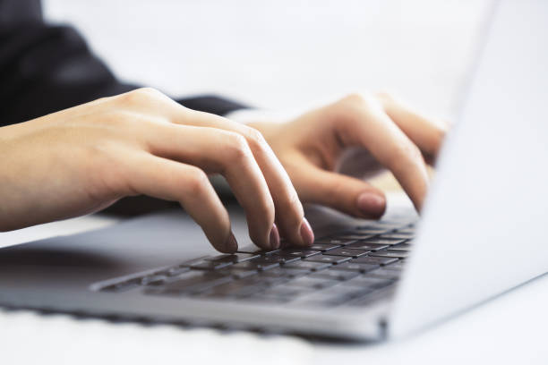istock Woman's hands, in close-up, typing on a stylish laptop keyboard, amidst a blurry office setting 1502537902