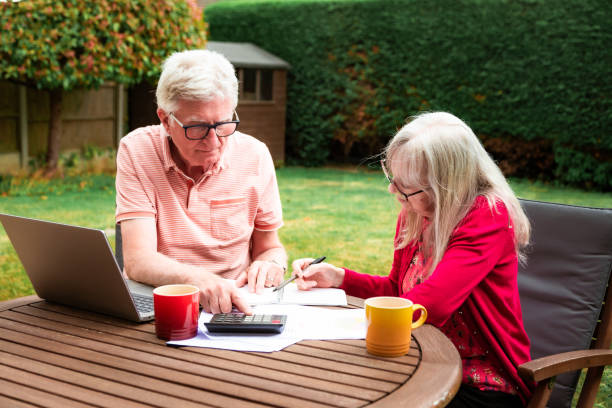 istock Senior couple checking finances outdoors in garden 1502539261