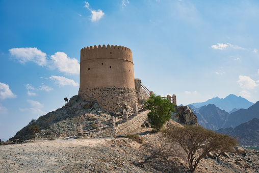 Old rock made fort standing above scenic landscape of Hatta mountainous city in the territory of Dubai emirate of United Arab Emirates during a bright day