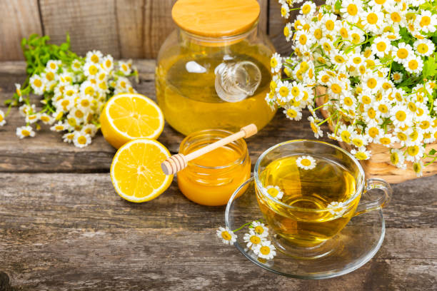 istock Chamomile tea in a cup on a brown textured background. Natural hour with chamomile flowers. Herbal tea. Natural healer concept. Healthy detox drink.Close up. Place for text. Copy space. 1502542248