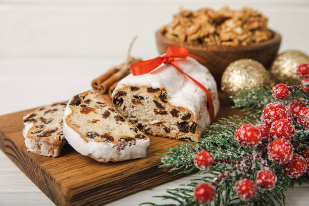 크리스마스 슈톨렌은 나무 테이블 위에 놓인 독일 전통 빵입니다. 가루 설탕을 뿌린 반죽, 견과류, 마지팬으로 만든 축제 디저트. 복사 공간. 텍스트를 위한 위치입니다. - christmas stollen christmas pastry baked 뉴스 사진 이미지