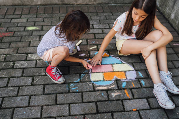 istock Children drawing colorful hearth shape with chalks on the ground 1502545974