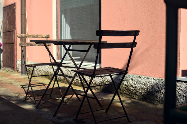 istock Chairs and table in a garden next to an open window 1502549107
