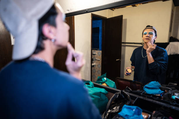 istock Young man putting on makeup backstage to perform as a drag queen in theater 1502551495