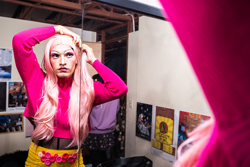 Drag queen getting dressed backstage before performance at theater