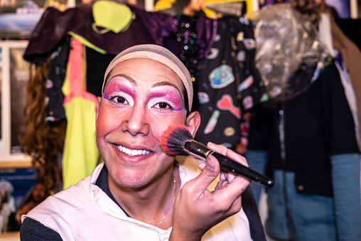 Portrait of a drag queen doing makeup backstage at the theater