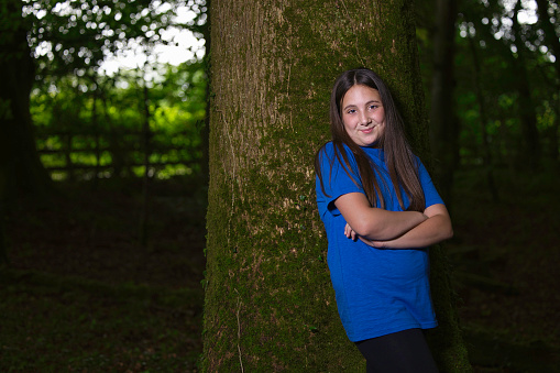 Pre-teen brunette enjoying a walk in Welsh woodland.