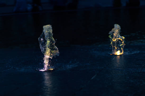 Jets of water in the pool, illuminated from the inside by light at night