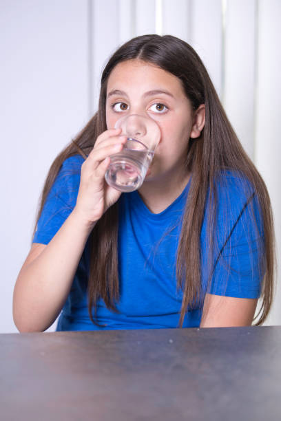 istock Eleven-year-old girl with brown eyes drinking 1502554104