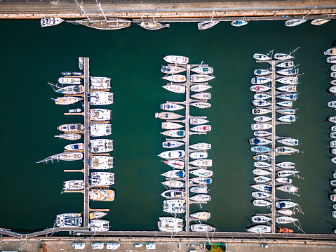 Aerial perspective of dock with recreation boats aligned and tied to the pontoon