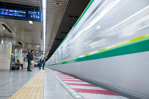 Tokyo, Japan - February 18, 2018: Tokyo Subway Metro Station with Fast Moving Train and Blurry people because of long exposure.