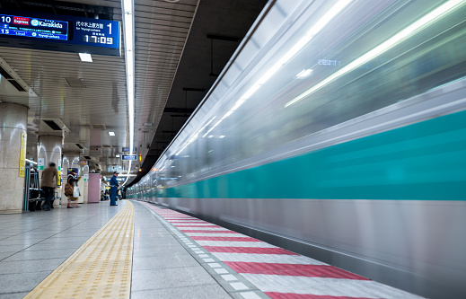 Tokyo, Japan - February 18, 2018: Tokyo Subway Metro Station with Fast Moving Train and Blurry people because of long exposure.