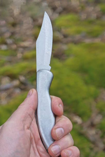 istock hand holding one gray metallic open folding knife 1502567365