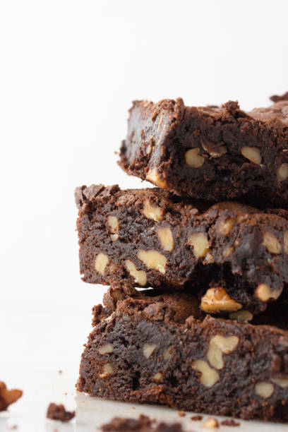 istock Stack of chocolate brownies and nuts on white background. 1502571260