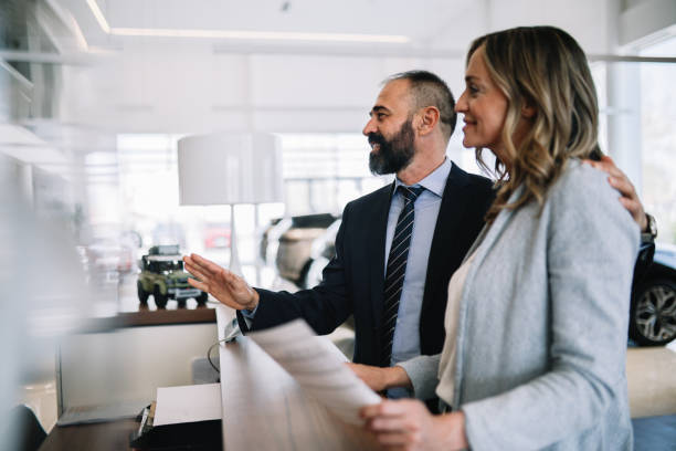 istock mid age couple visiting the car showroom 1502572167