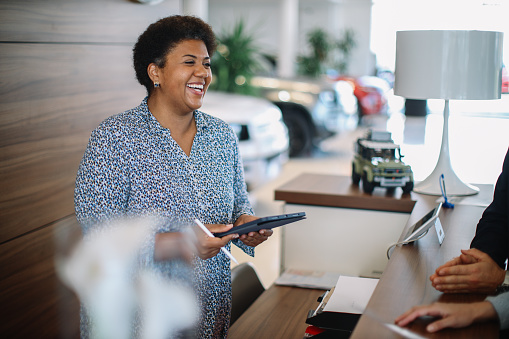 Salesperson in the car dealership showroom.