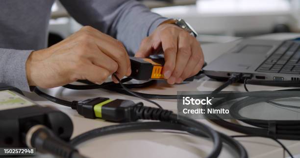 Cropped Shot Of Male Itspecialist Connect Wires To Gadget And Fix Laptop Stock Photo - Download Image Now