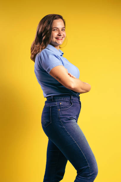 ritratto di una donna brasiliana, che indossa una polo e jeans, di profilo, con le braccia incrociate, sorridente e guardando la macchina fotografica - belém - pará - brasile - polo shirt flash foto e immagini stock