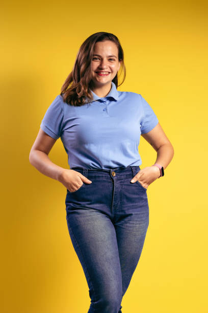 ritratto di una donna brasiliana, che indossa una polo e jeans, con le mani nelle tasche dei pantaloni, sorridente e guardando la macchina fotografica - belém - pará - brasile - polo shirt flash foto e immagini stock