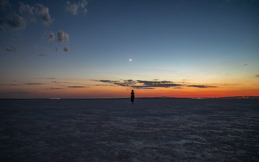 Crescent and a woman watching the view at sunset in the salt lake