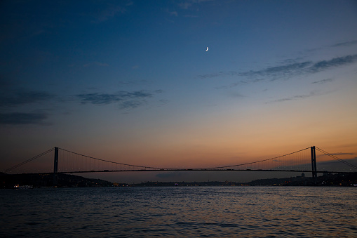 Moon view over Bosphorus bridge at sunset