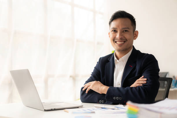istock Asian businessman writing financial graph chart marketing information plan Male hand using laptop at desk reading financial document spreadsheet for calculation and analysis. 1502629334