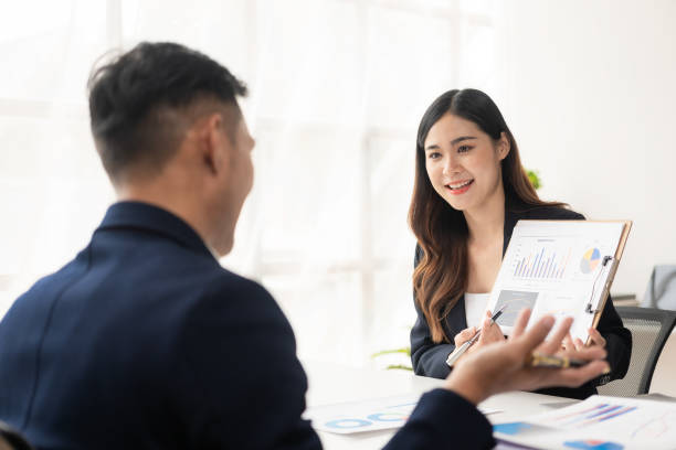 istock Smart and professional male manager working with his female assistant. check financial reports Analyze financial data with graph papers and laptop with desk. 1502629449
