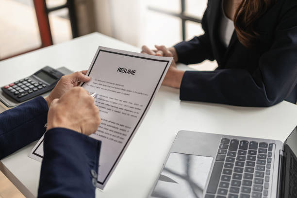 istock The right candidate gives the interviewer a resume during a job interview in a modern office conference room. woman submitting job application The interviewer reads the resume. 1502629571