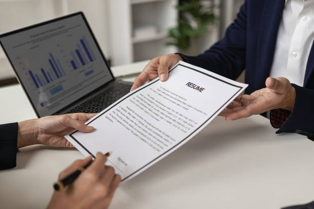 istock The right candidate gives the interviewer a resume during a job interview in a modern office conference room. woman submitting job application The interviewer reads the resume. 1502629572
