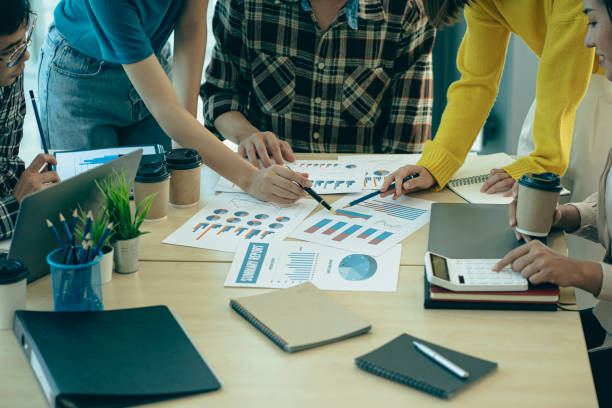 istock Group of young Asian businessmen in smart casual clothes analyzing financial data graphs brainstorming together at work meeting 1502629748