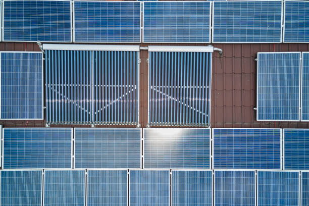 techo de construcción con filas de paneles fotovoltaicos azules y colectores solares de aire al vacío para calentar agua y producir electricidad ecológica limpia. energía eléctrica y térmica renovable con cero emisiones - solar power station sun water collection fotografías e imágenes de stock