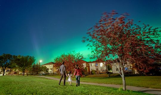 Asian parents and child admiring Northern Lights