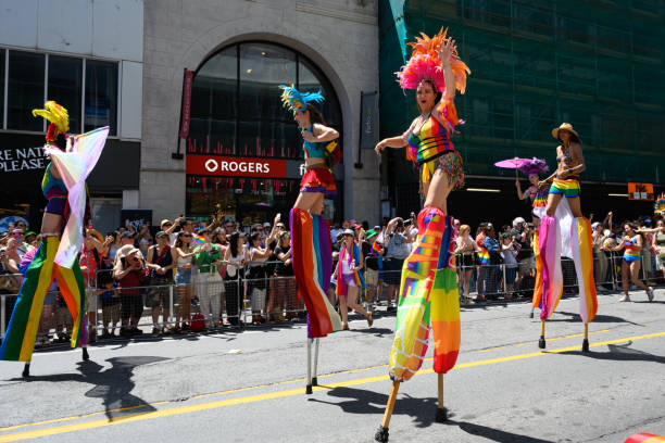 personas sobre zancos celebran en el desfile pride toronto 2023 el 25 de junio - royal bank of canada fotografías e imágenes de stock