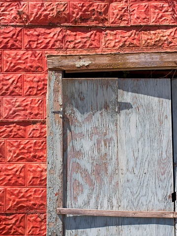 Weathered blue door and red tin siding in Taos New Mexico. Decaying barn at the site of San Francisco de Asis Catholic mission church