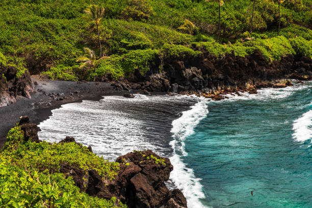 знаменитый пляж с черным песком и потрясающий вид на побережье мауи по дороге в хану в солнечный день - black sand beach hawaii islands maui стоковые фото и изображения