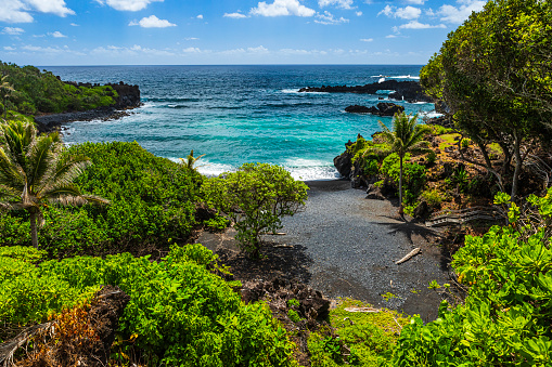 Wai'ānapanapa famous black sand beach and stunning coastal view in Maui on the road to Hana on a sunny day.