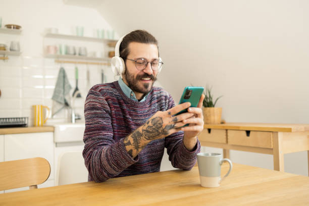 istock Happy young man using a mobile app for listening music 1502673583