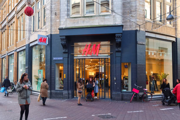 entrance of shop or store at main street Den Haag, Netherlands - November 01 2021: the entrance of a big chain fast fashion store downtown with shoppers h and m stock pictures, royalty-free photos & images