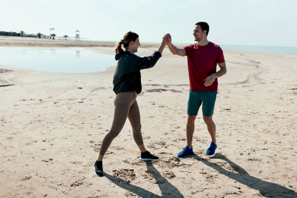 istock Man and woman doing cardio exercises on the beach 1502674477